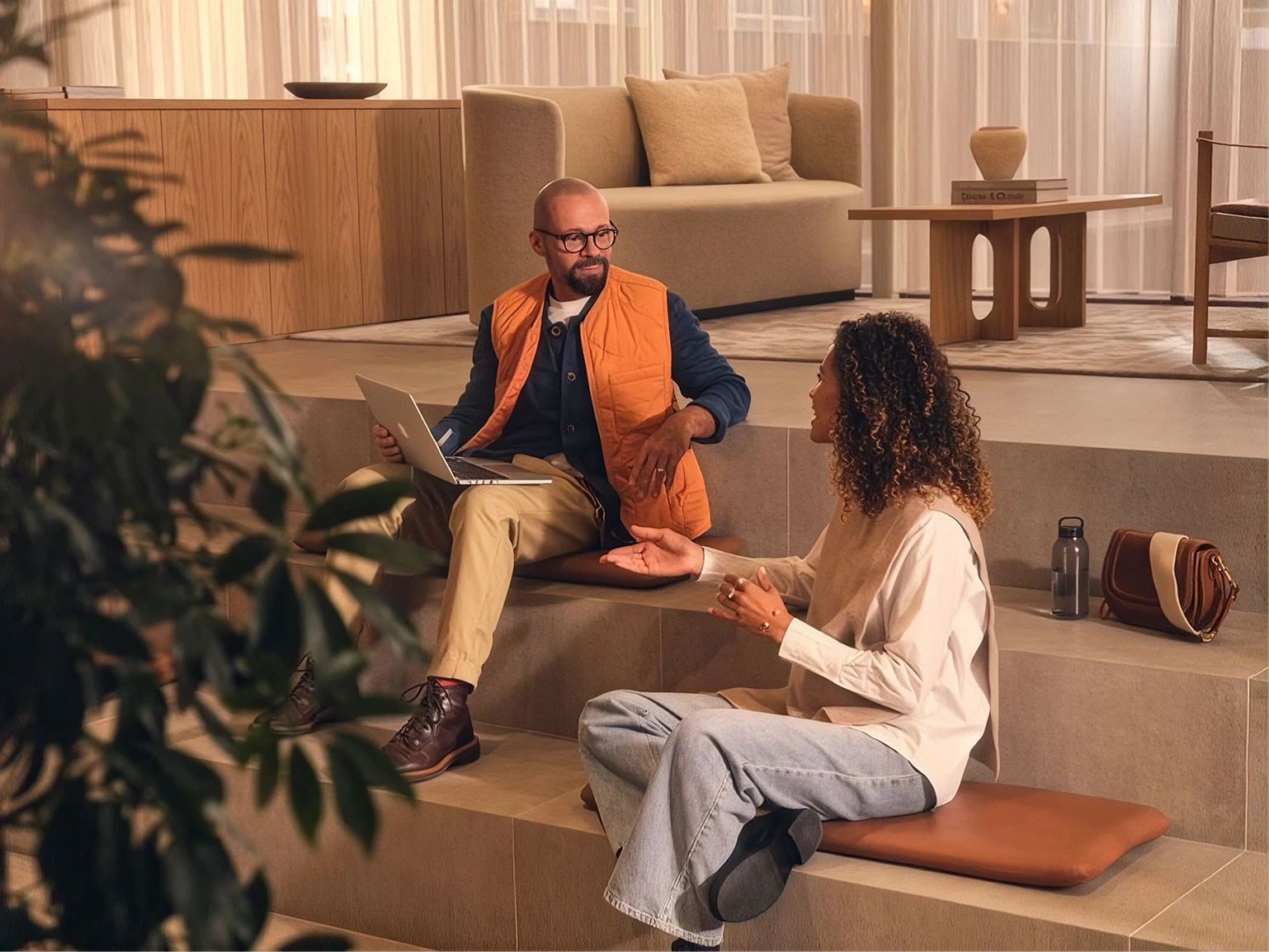 Two people in unhurried conversation in a warm, light-filled space.